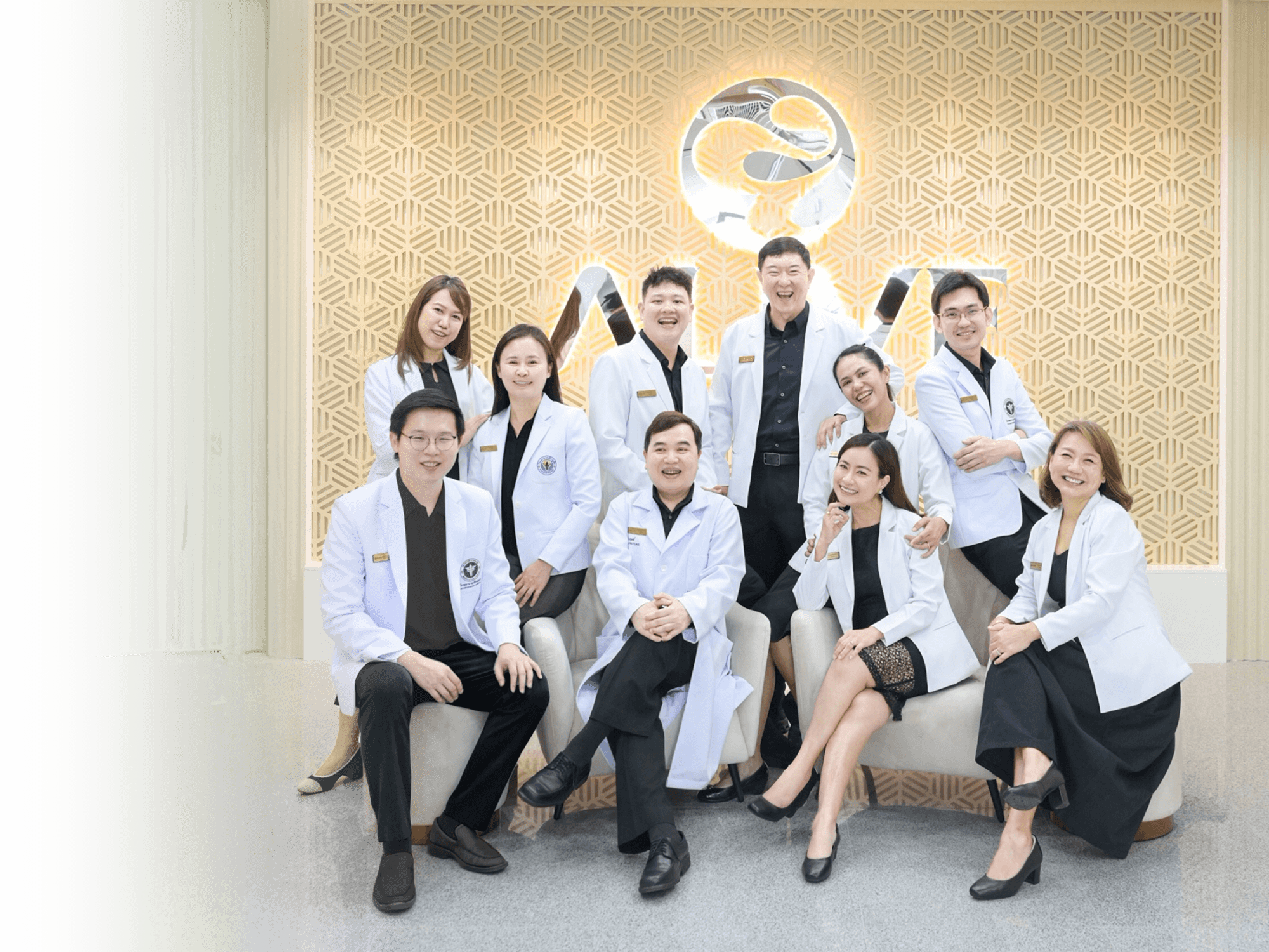 ALIVE clinic medical team — eleven doctors and staff seated together in front of the ALIVE wall logo